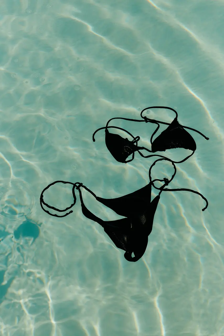 Dark swimwear floating in rippled turquoise water