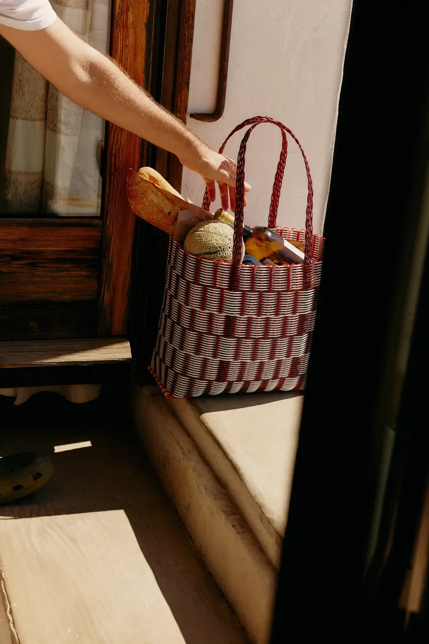 Striped woven bag resting beside a sunlit window frame